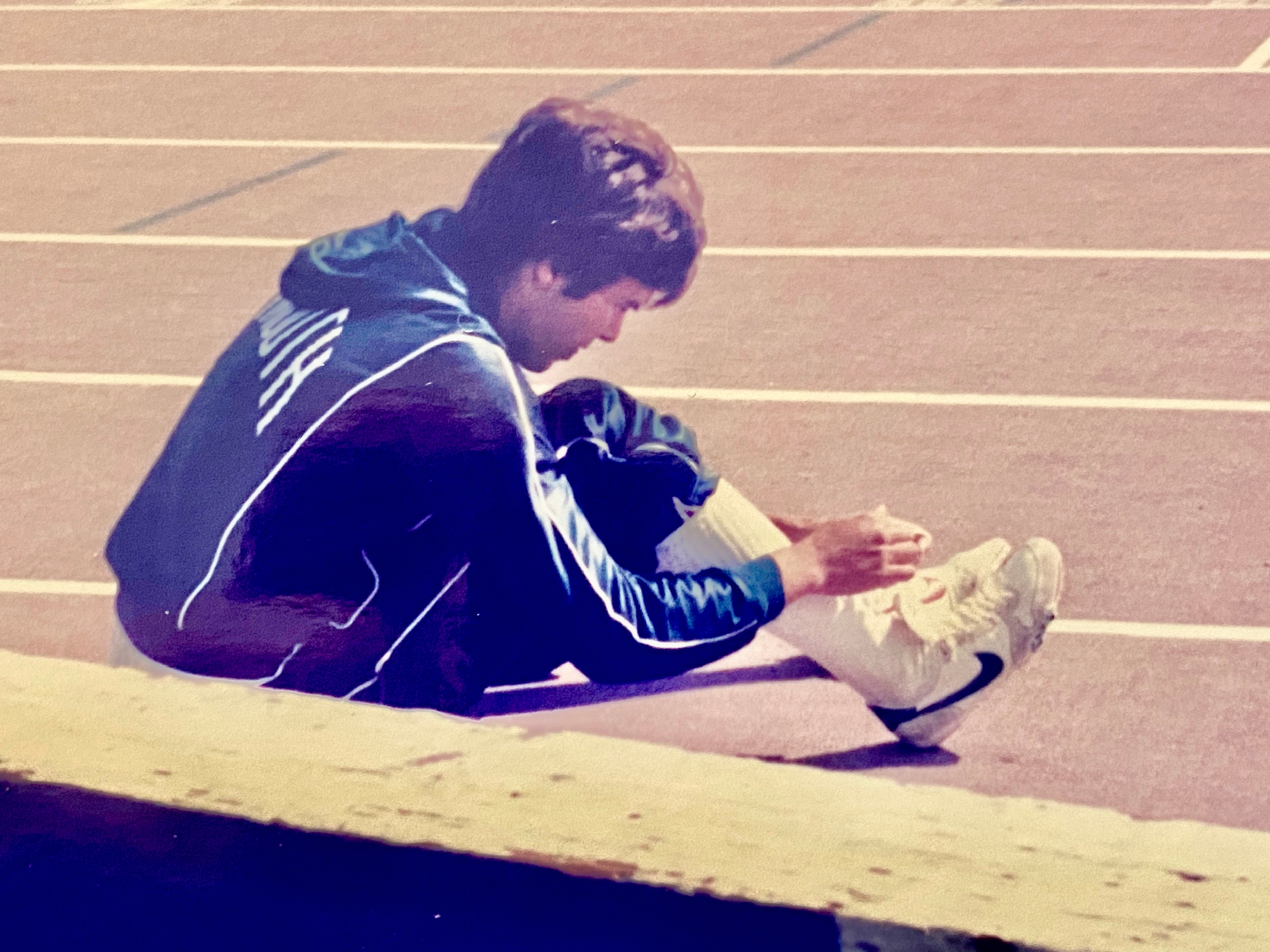 Photo of a young Dave Girouard, lacing up before a 400M race at Dartmouth.